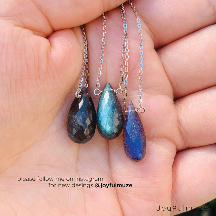 3 labradorite pendant necklaces in a hand